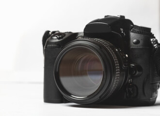 Digital camera close up on work desk. Photographic. White background. Equipment for the photographer.