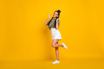 Fototapeta na wymiar Photo portrait full body view of cute girl standing on one leg isolated on vivid yellow colored background