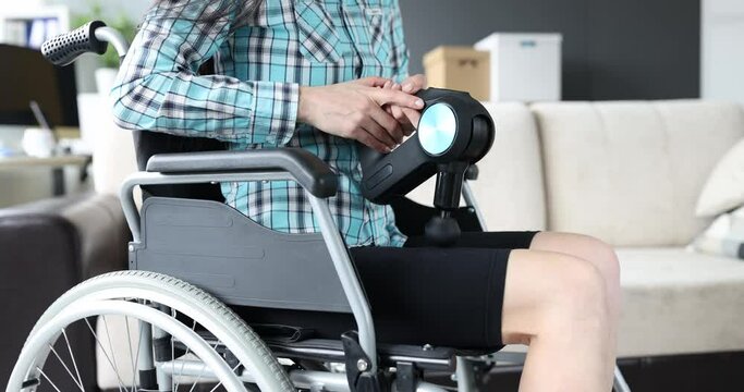 Disabled woman in wheelchair doing leg massage with percussion massager closeup 4k movie