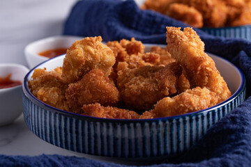 Crispy Chicken Pops Korean Style with Ketchup Chili sauce. Dark tone.