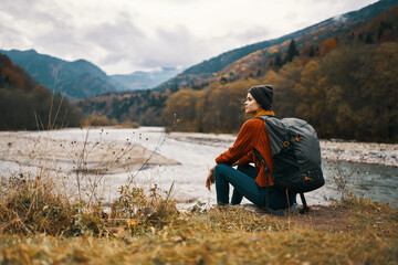 woman travels in the mountains near the river in the meadow in the forest rest relax