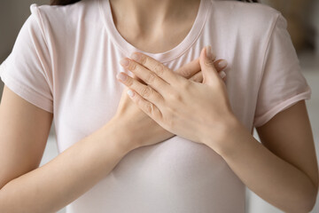 Grateful young woman applying hands on chest, expressing love, honesty. Cropped shot of girl in...