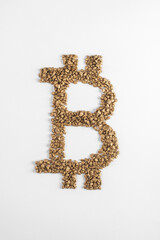 Top view on bitcoin sign made from pieces of gold on white background