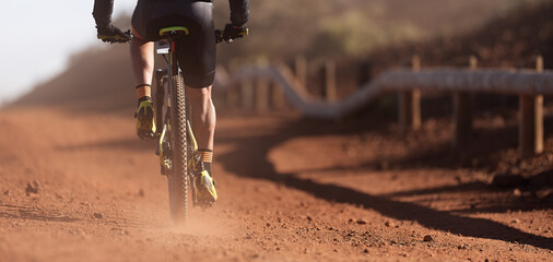 Mountain biker riding on bike singletrack trail, back view of mountain biker. Mountain bike race