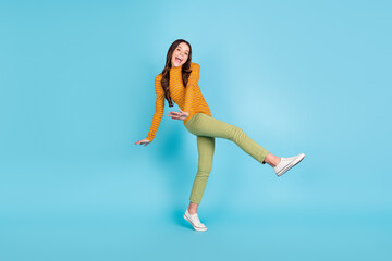 Full length photo of excited cheerful pupil dancing raise leg open mouth look camera isolated on blue color background