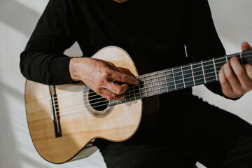 photo of man playing classical guitar