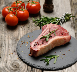 fresh piece of beef, striploin steak on a black board with spices