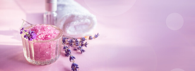 Lavender salt with natural spa products and bath decor on a pink background. copy space. Banner