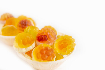 Macro photography of jelly-like craft marmalade with orange juice. The sweetness of yellow and orange jelly candies on a light table. Low depth of field, selective focus. Isolated