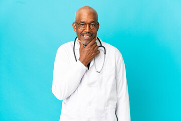 Senior doctor man isolated on blue background happy and smiling
