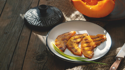 Grilled pumpkin slices. Pumpkin slices served in a frying pan, close-up