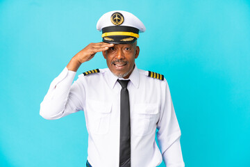 Airplane pilot senior man isolated on blue background doing surprise gesture while looking to the side