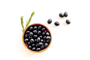 Black olives in wooden bowl. Overhead view