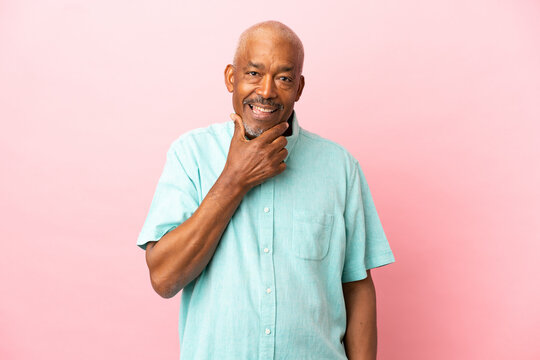Cuban senior isolated on pink background happy and smiling