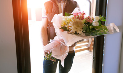 The delivery man delivers a bouquet of beautiful flowers to home