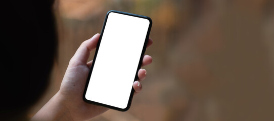 Top view Woman sitting on work desk and holding blank screen mock up mobile phone.