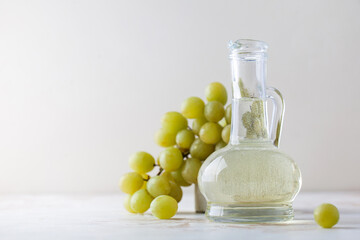 Organic vegetable oil from grape seeds in a glass bottle with green grapes. 