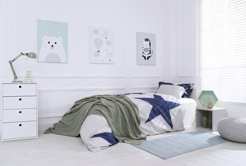 Bed with stylish linens in children's room