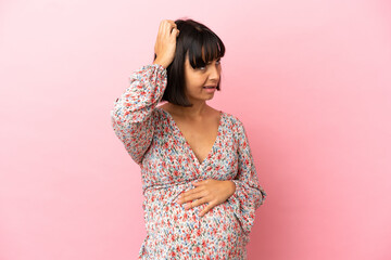 Young pregnant woman over isolated pink background having doubts while scratching head