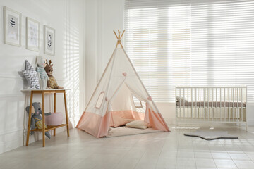 Comfortable crib and play tent in baby room. Interior design © New Africa