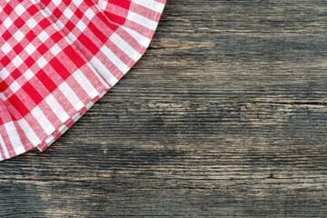 Red checkered towel on the kitchen table. Wooden table background.