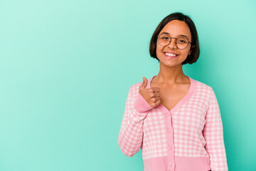 Fototapeta premium Young mixed race woman isolated on blue background smiling and raising thumb up