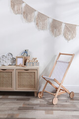 Drawer unit and wooden buggy indoors. Children's room interior