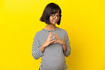 Young pregnant woman over isolated yellow background scheming something