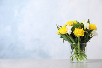 Beautiful bouquet with peony tulips on table against light blue background, space for text