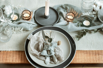 Festive table setting in vintage style with dry sprigs of leaves close up.