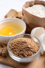 Fresh breadcrumbs, flour and egg on table