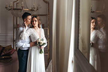 Portrait of the bride and groom in a lace dress in boho style with a bouquet.