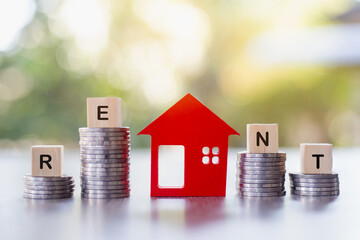 Red houses and a pile of coins. Concept of renting a house for residence. Money from business finance coins. Successful financial business. Savings for real estate projects, mortgages, rentals.