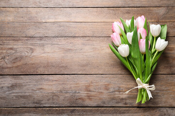 Beautiful pink spring tulips on wooden background, top view. Space for text