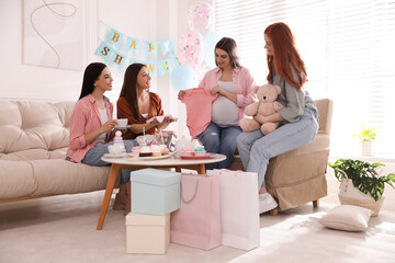 Happy pregnant woman spending time with friends at baby shower party - obrazy, fototapety, plakaty