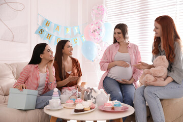 Happy pregnant woman spending time with friends at baby shower party - obrazy, fototapety, plakaty