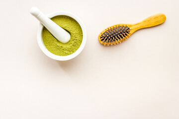 Henna hair dye powder and wooden comb. Henna in wtite mortar