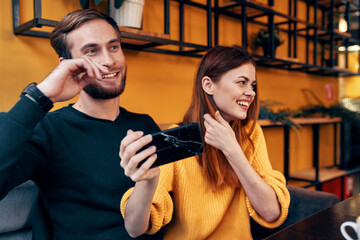 Naklejka premium woman with mobile phone and happy man friends fun family communication interior
