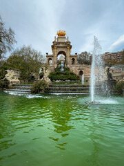 Pond and Fountain cascades with Stone arch, staircases and golden sculptures in Parc De la Ciutadella, Barcelona, Spain