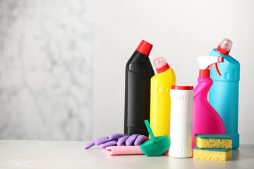 Different toilet cleaning supplies and tools on light grey table, space for text