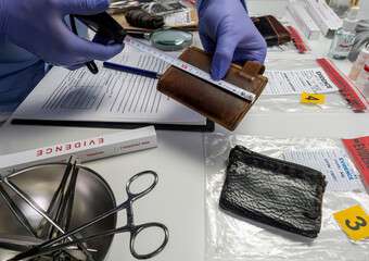 Specialised police officer measures wallet in crime lab, conceptual image