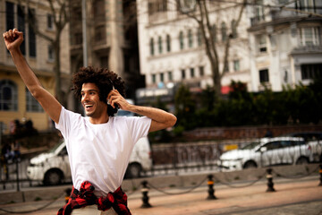 Obraz premium Young man outdoors. Handsome man listening music while walking through the city.