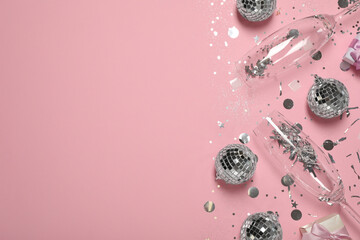 Bright shiny disco balls, confetti and glasses on pink background, flat lay. Space for text