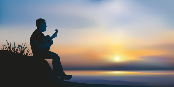 Concept de l’inspiration et de la méditation avec un musicien seul, qui joue de la guitare assis devant un coucher de soleil sur l’océan.