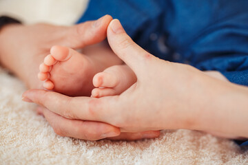 Baby foot in mother hands.