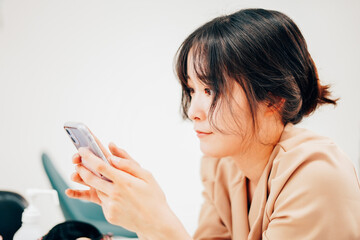 スマホでSNSをチェックする若い女性