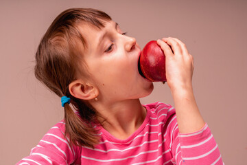 It's really tasty and healthy food! Young beautiful girl bites apple. Copy space for design.