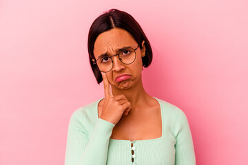 Young mixed race woman isolated on pink background crying, unhappy with something, agony and confusion concept.