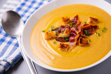 Hot vegetable cream with ham and olive oil 