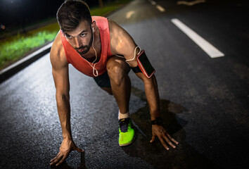 Man preparing to run through the city at night.